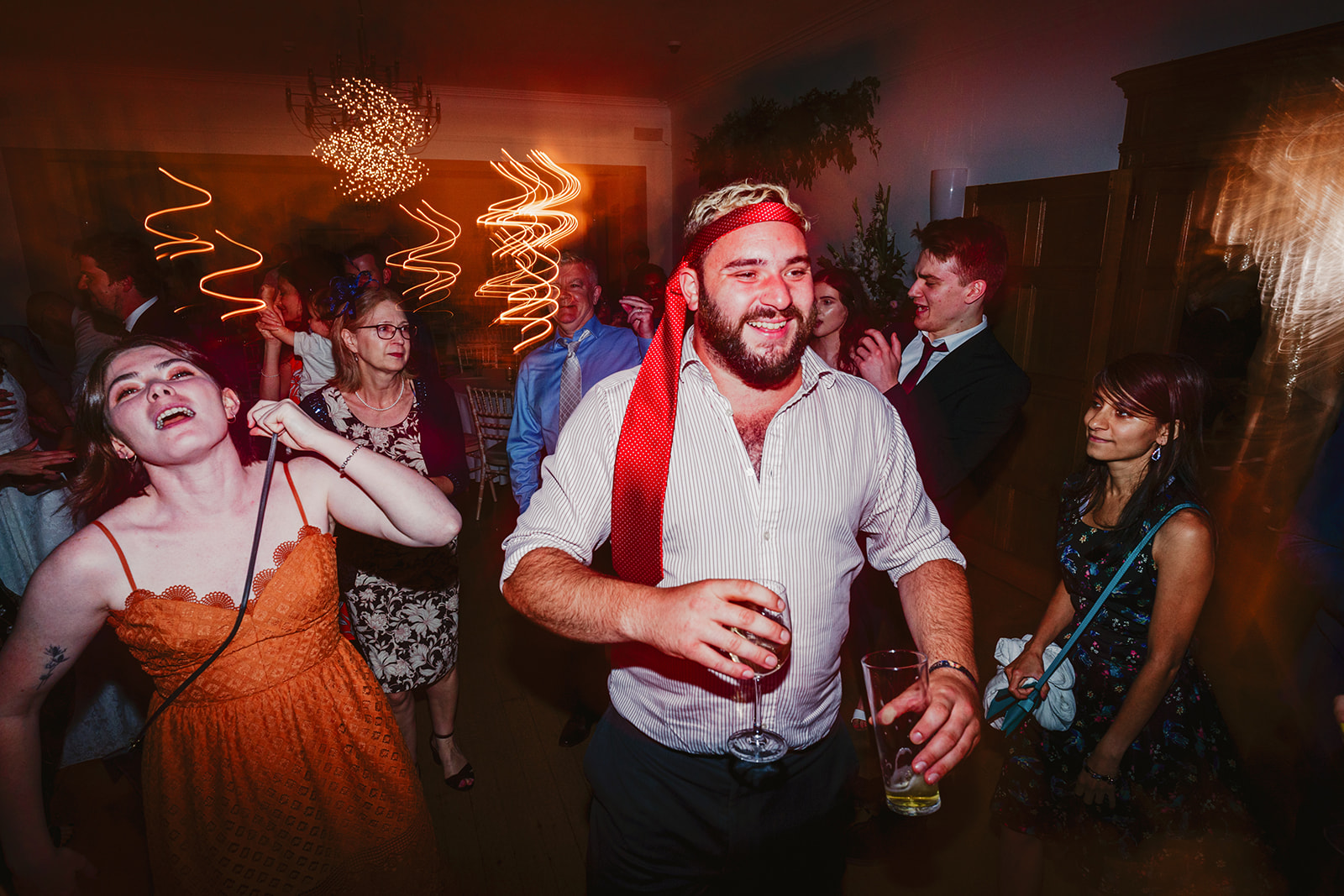 A lively group of people dancing at a party, captured by a talented Bristol wedding photographer.