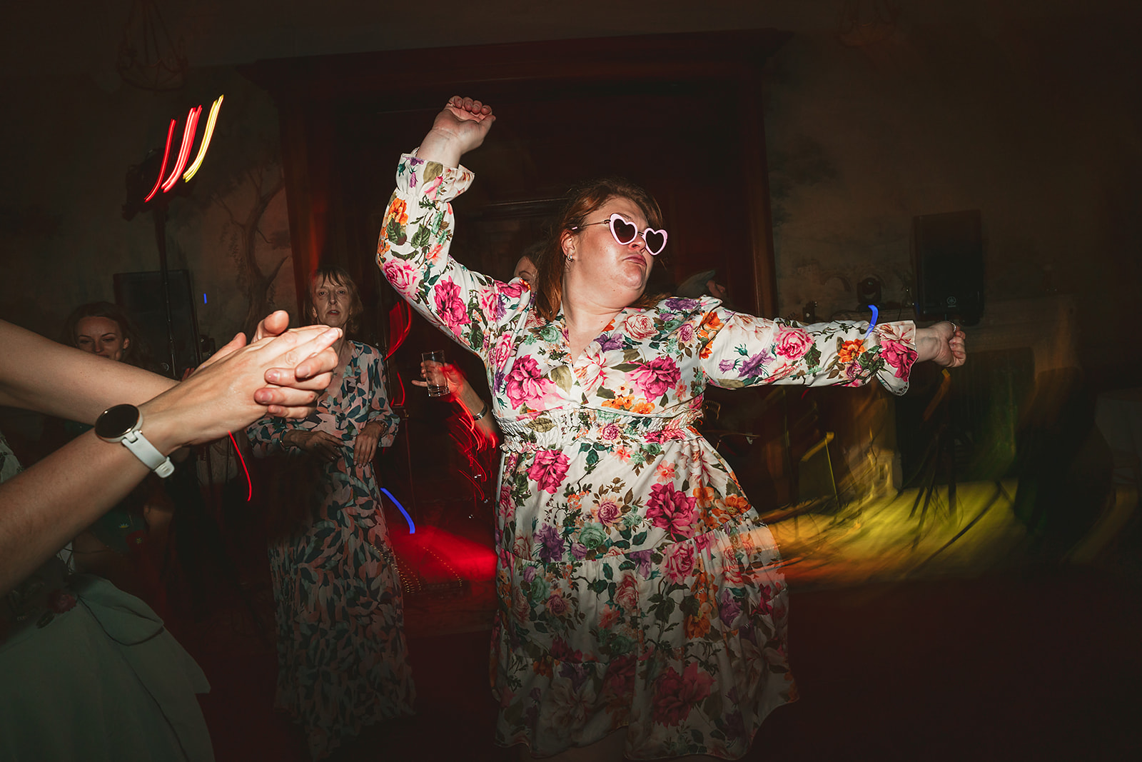 A woman in a floral dress dancing at a Clevedon Hall party.