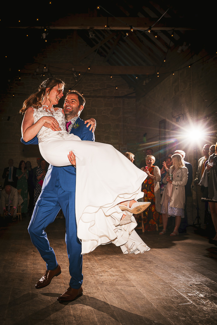 A groom picks up his bride during a first dance photographed by a Wiltshire wedding photographer