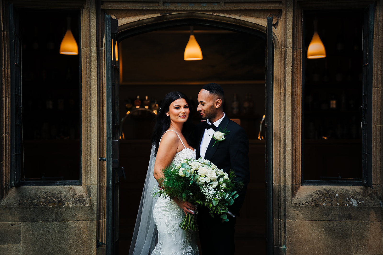 A bride and groom posing in front of a doorway photographed by Bristol wedding photographer at Coombe Lodge Blagdon